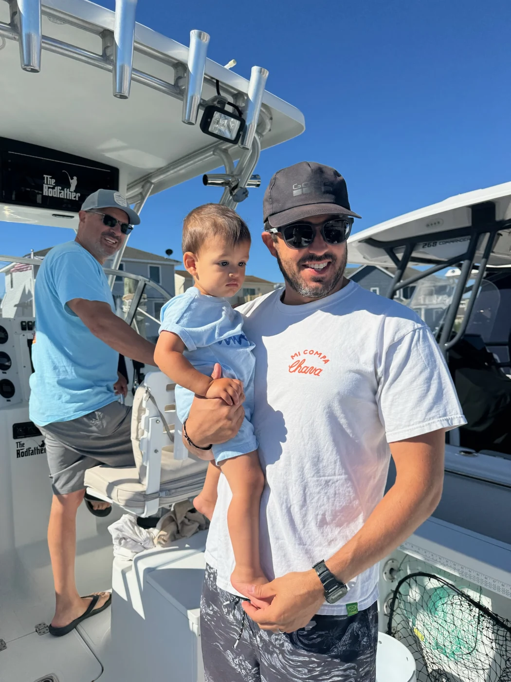 Steven holding his young son on a center-console fishing boat